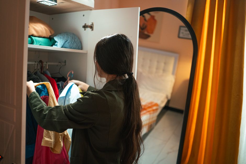 Woman organizing clothes in a perfectly arranged wardrobe